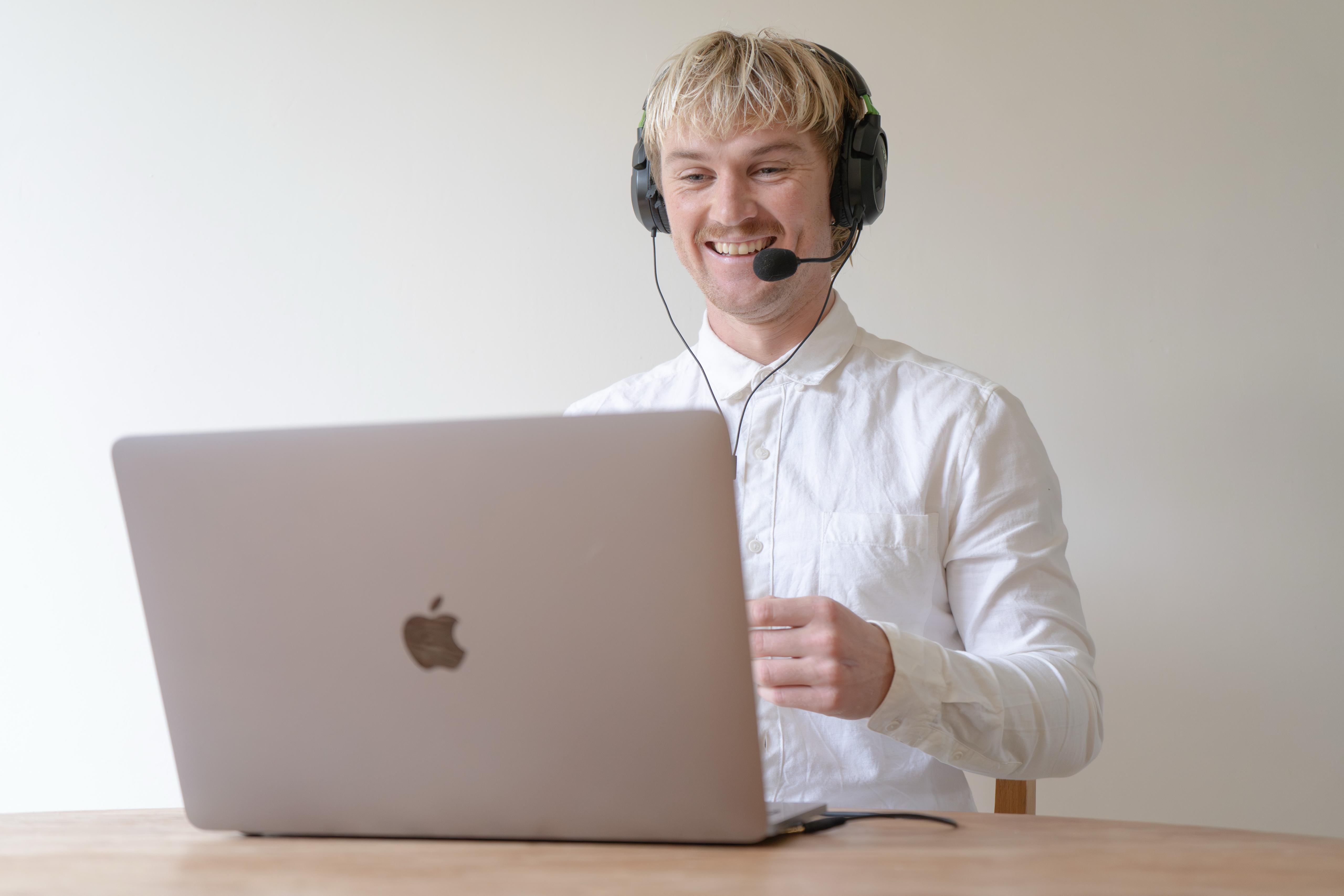 Jacob Glover coaching online with a headset and laptop